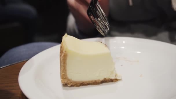 Menina comendo cheesecake fresco com um garfo enquanto sentado na cozinha ou em um café. Movimento lento . — Vídeo de Stock
