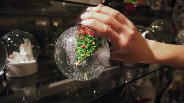 Female hand shaking a snow globe. Slow motion. — Stock Video