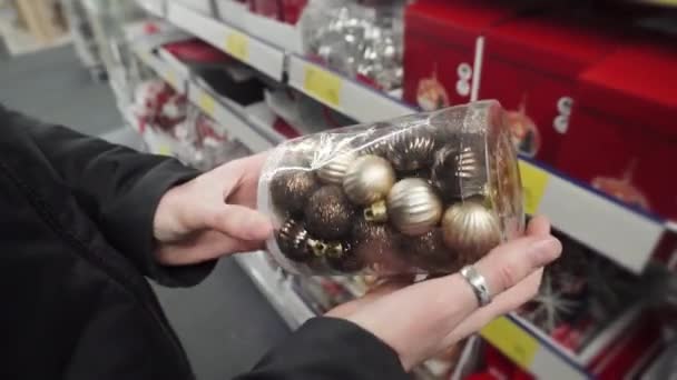 Compras para las fiestas de Navidad, mujer eligiendo bolas de oro para el árbol de Navidad. 4k UltraHD . — Vídeo de stock