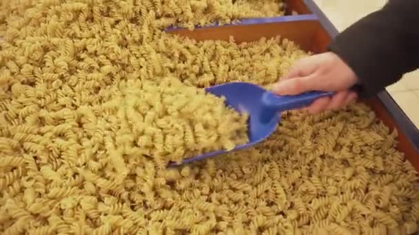 Pasta in vakken op de teller in de supermarkt. Jonge vrouw granen in de winkel kopen. — Stockvideo