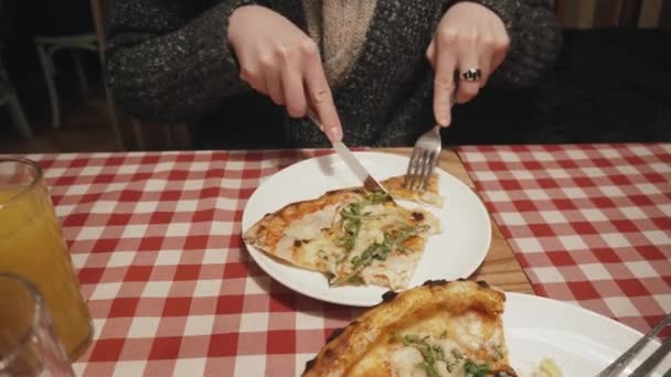 Hungrige Frau isst in Restaurant mit Gabel und Messer Pizza. — Stockvideo