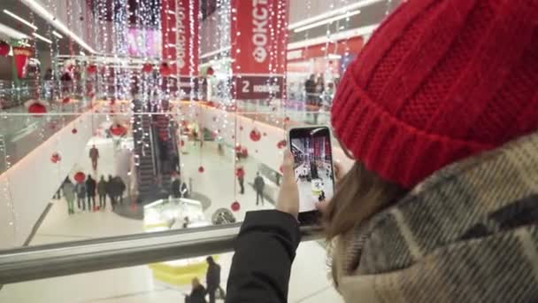 SUMY, UCRANIA - 16 DE DICIEMBRE DE 2018: Jovencita alegre en traje de moda graba video timelapse para su video blog mientras está en el centro comercial . — Vídeos de Stock