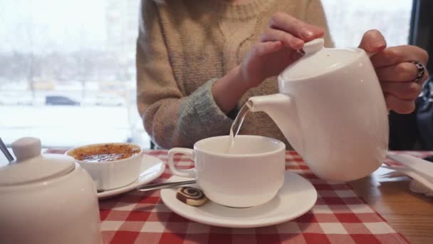 Mujer casual vertiendo té orgánico en la taza de cerámica . — Vídeo de stock