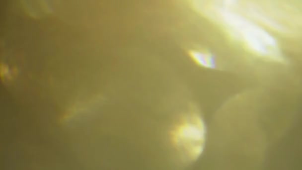 Echte Lens flare lichteffect op zwarte achtergrond. Warme bokeh. — Stockvideo