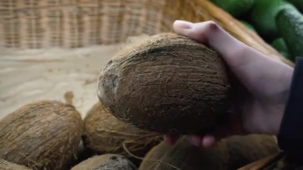 A mão de uma jovem escolhe um coco no supermercado local . — Vídeo de Stock