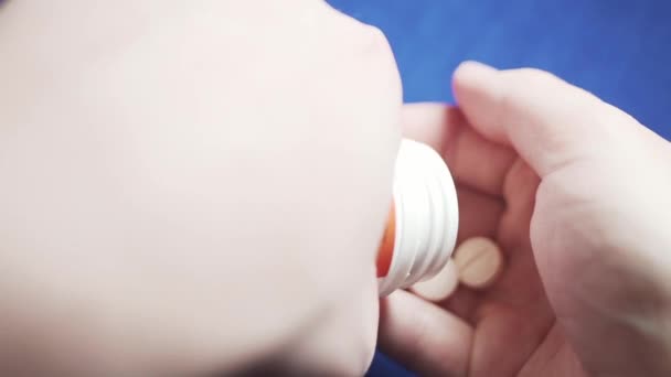 Un homme verse des pilules blanches dans sa paume. Mouvement lent .