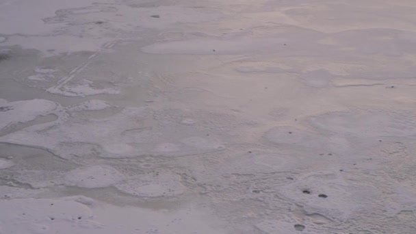 足跡を雪に覆われた凍った川のクローズ アップ. — ストック動画