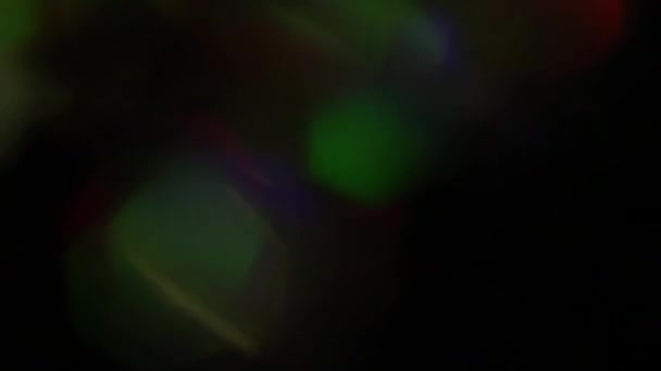 Des reflets holographiques arc-en-ciel, des couleurs vives scintillant sur un fond sombre. Contexte créatif, transition ou éblouissement .