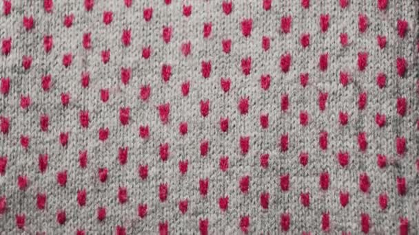 Looped, abstract texture, pattern. Knitted gray fabric with red dots. Warm scarf close up. — Stock Video