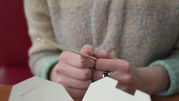 Young woman prepares to use chopsticks. Close up of female hands holding the chopsticks for udon. — Stock Video