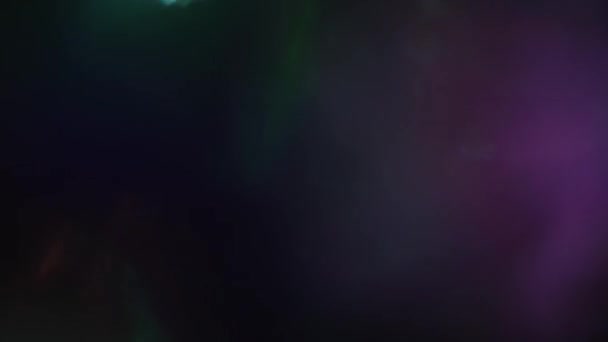 Mélange de couleurs dans l'obscurité. Bokeh multicolore fusionnent lentement et se déplacent dans l'obscurité .