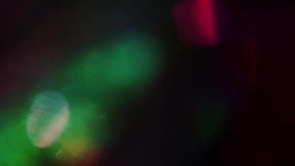 Caleidoscoop van heldere regenboogkleuren, reflecties van een holografisch folie flikkeren in het donker. — Stockvideo