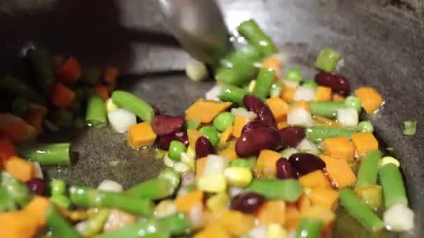 Flicka blandar vegetabilisk blandningen med en sked och visar dem i närbild. — Stockvideo