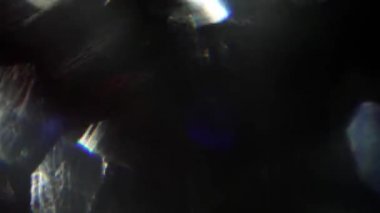 Hızlı hareket soyut ışık sızıntıları, yanardöner holografik folyo yansımaları karanlıkta.
