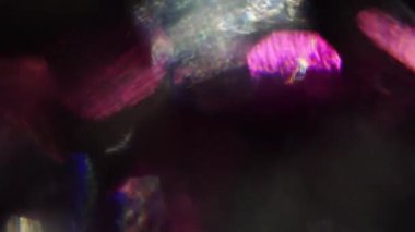 Yanardöner arka plan. Renkli kristal parçacıkları, hızlı bir şekilde karanlıkta titreşim.