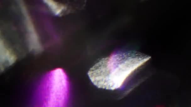 Des formes abstraites violettes scintillant sur un fond sombre . — Video