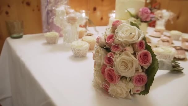 Schöner Rosenstrauß auf dem Hochzeitstisch in einem Luxusrestaurant. — Stockvideo