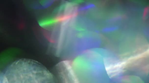 Holografisch folie psychedelische achtergrond glinsterende kleurrijke bokeh in een zwarte kamer. — Stockvideo
