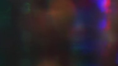 Karanlık arka planda parlayan çok renkli holografik ışık sızıntıları. Doğal oluşturulan geçiş.