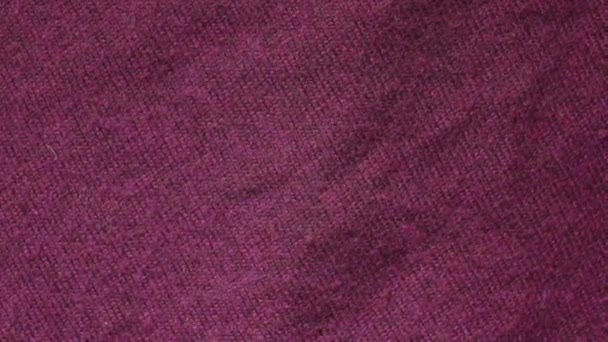 Slow pan of a burgundy color polymer acrylic sweater in a textiles shop. — Stock Video