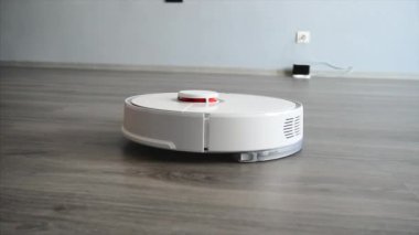 Akıllı robotik elektrikli süpürge oturma odasında zemin temizler.