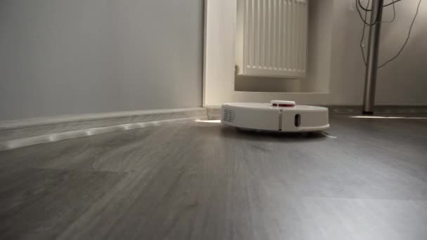 Autonomiczna zautomatyzowana odkurzacz inteligentna maszyna czyści laminowaną podłogę. — Wideo stockowe
