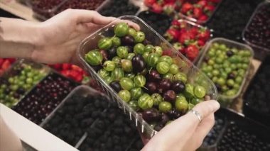 Süpermarkette taze bektaşi üzümü alan kız. Yavaş çekim.