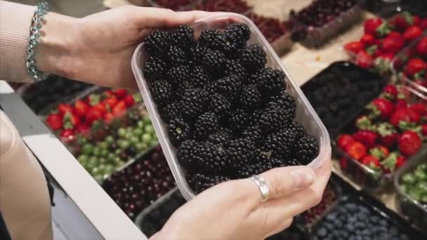 Mulher vegetariana escolhe amora no balcão da loja no supermercado . — Vídeo de Stock