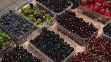 Piyasada satmaya hazır plastik kutularda taze organik çilek karışımı. 
