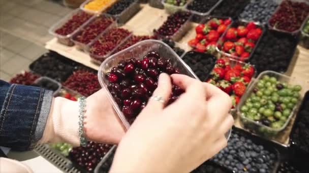 Vegetarische vrouw kiest voor cornelse kersen in de supermarkt. — Stockvideo