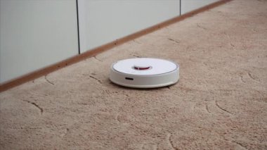 Halı boyunca modern robotik elektrikli süpürge slaytlar, anaokulunda toz kaldırır.