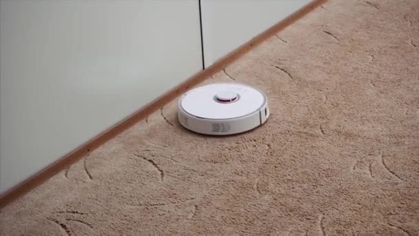 Concetto di casa intelligente. robot robot robot aspirapolvere pulisce il tappeto in casa . — Video Stock