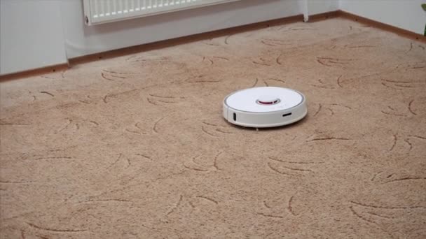 자동 로봇 진공 청소기가 놀이방에서 카펫을 청소합니다.. — 비디오