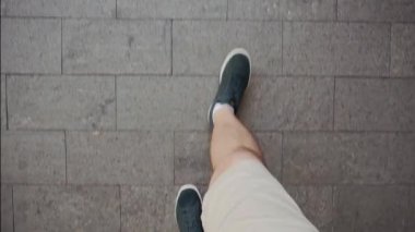 Kaldırım tabakalarında yürüyen adam. Yukarıdan bak. Yavaş çekim.