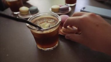 Bir adam Fransız makarnası yer ve soğuk espresso tonik içer.. 