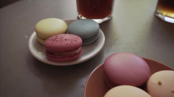 Vícezbarvené francouzské makarvové sušenky s různými náplní na deskách. — Stock video