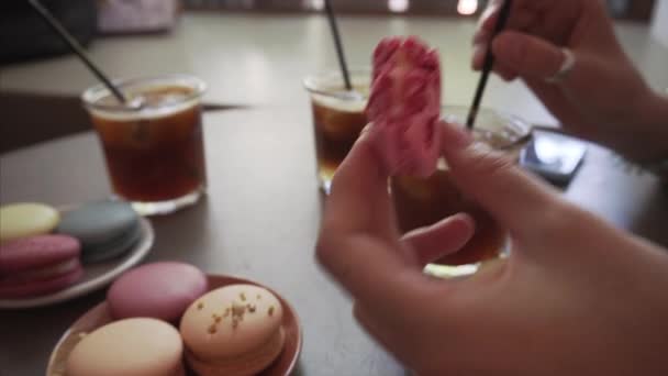 Menina gourmet come macaron francês e bebidas de café gelado . — Vídeo de Stock