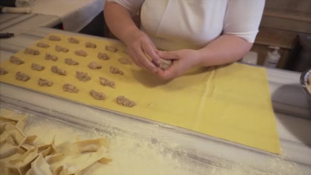 Mujer prepara manualmente ravioles con relleno de carne - un plato tradicional italiano . — Vídeos de Stock