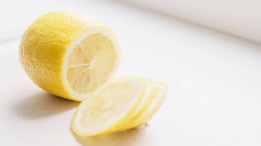 Kesme tahtasında sarı sulu limon ve birkaç turunçgil dilimi..