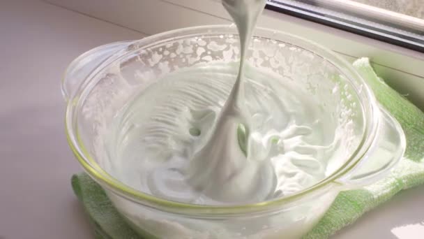Een chef-kok of huisvrouw controleert de gereedheid van de Italiaanse meringue op de garde van een keukenmixer. — Stockvideo