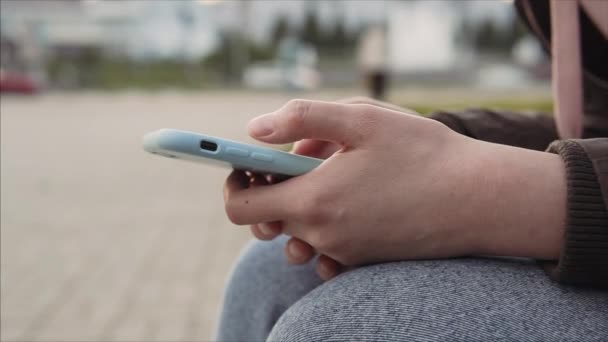 Närbild av händerna på en flicka som surfar webbnyheter på en smartphone med hjälp av Internet. — Stockvideo