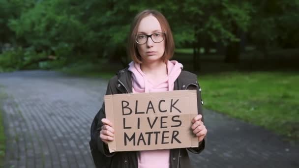 Zwarte Levens zijn belangrijk. Meisje met karton ter ondersteuning van burgerrechten en mensenrechten. — Stockvideo