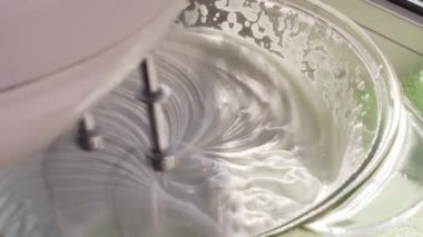 İtalyan kremalı pasta karıştırıcısı için şekerli yumurta çırpıyor..