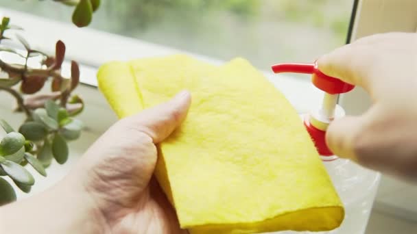 Ένα άτομο πιέζει μια σταγόνα απολυμαντικό τζελ απολυμαντικό σε ένα κίτρινο πανί για να καθαρίσει το σπίτι. — Αρχείο Βίντεο