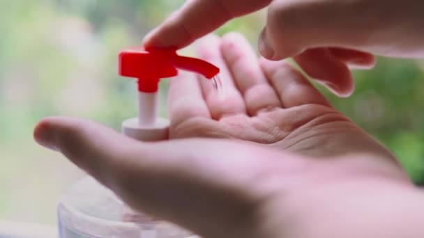 De mens knijpt een gel ontsmetter uit een dispenser een ontsmettingsmiddel op de palm. — Stockvideo