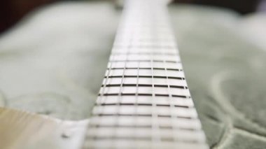 Elektro gitarın akçaağaç boynu yakın plan, ayrıntılı titreşim çekimi.