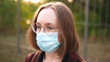 Tıbbi maskeli puslu gözlüklü bir kadının portresini yakından çek..