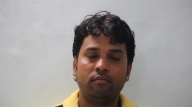 Genç Hintli adam surat yapıyor.