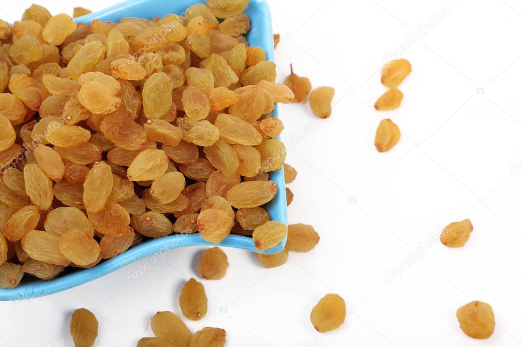 Bowl with dried golden raisins isolated on white. Dried Grapes.
