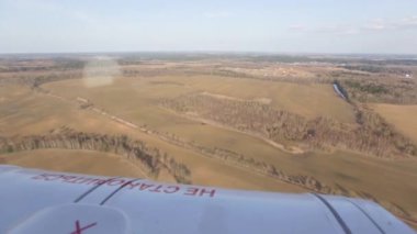 Uçuş açık, sıcak, güneşli havalarda, ormanlar, alanlar ve nüfuslu alanlar üzerinde helikopter. Uçak penceresinden görüntülemek.